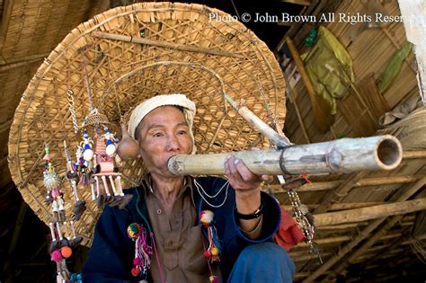 A Yao Ethnic Hill Tribe Man Is Smoking A Pipe And Wearing A Big Straw