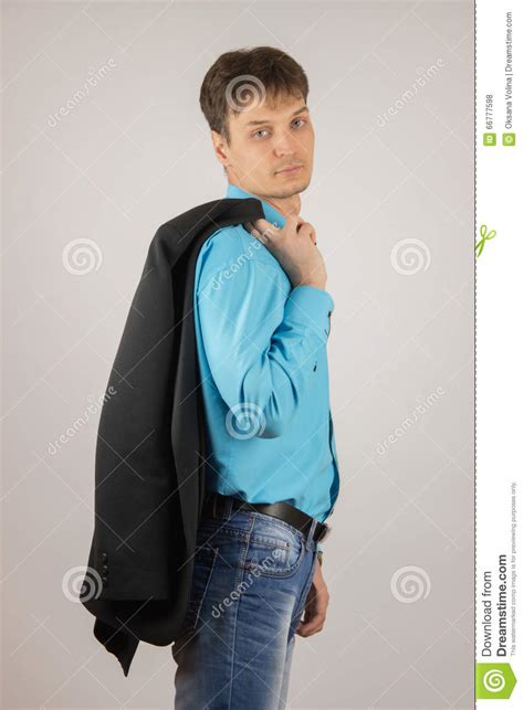 sexy stilvoller junger kerl in den jeans in einem blauen