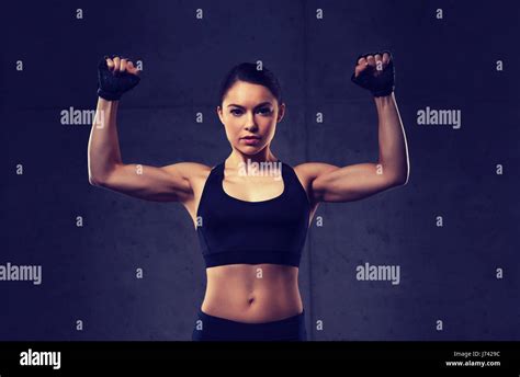 Mujer Joven Flexionando Los Músculos En El Gimnasio Fotografía De Stock