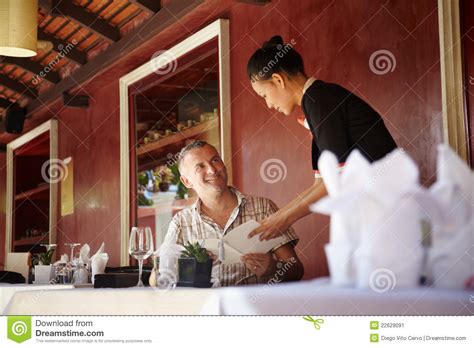 asian waitress talking with client in restaurant stock