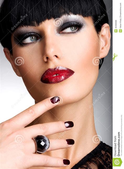 Face Of A Woman With Beautiful Dark Nails And Sexy Red