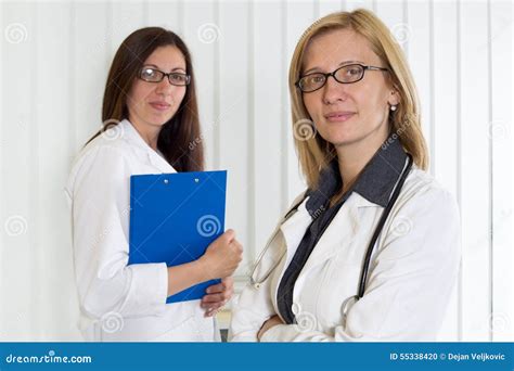 Portrait Of Two Middle Age Female Doctors Smiling And Looking At Camera