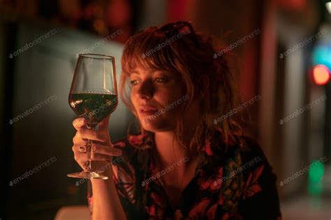 glass of red wine with beautiful ginger girl holding photo