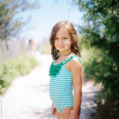 Cute Young Girl Standing By A Beach Walkway In A Bathing Suit By