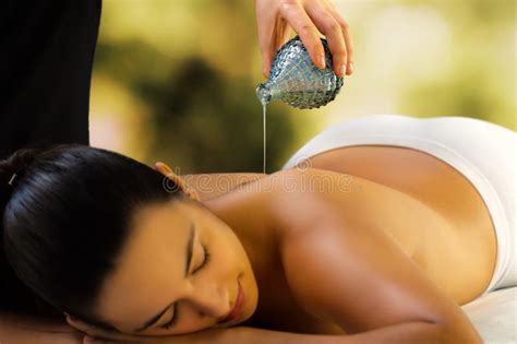 Pouring Massage Oil On Woman Back At Spa Stock Image