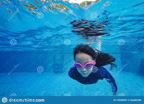 het gelukkige aziatische meisje zwemt en duikt de vakantie