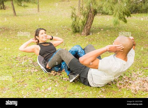 Fitness Couple Doing Abdominal Excersise Holding By The Legs Stock