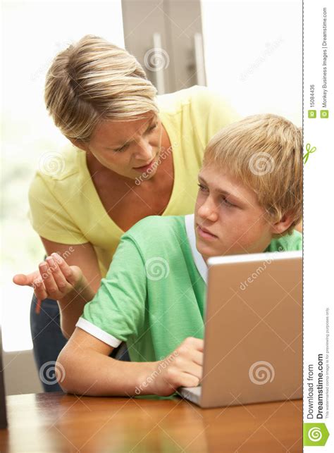 angry mother and teenage son using laptop at home royalty free stock image image 15084436