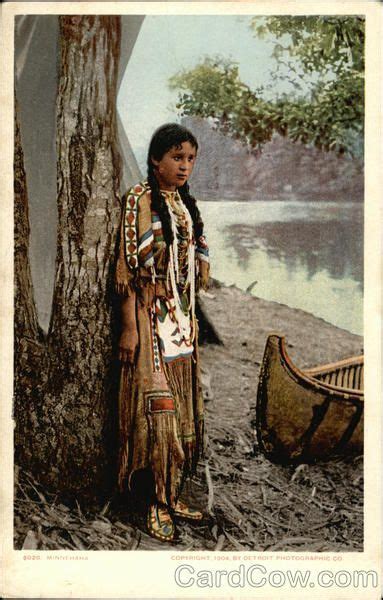 Indian Maiden In Traditional Outfit Stands By Canoe Native