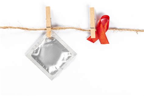 Premium Photo Red Ribbon And Condom With Clothespins Hanging On A Rope