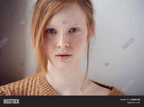 portrait of beautiful pensive girl with red hair at home cute redhead and freckles woman face