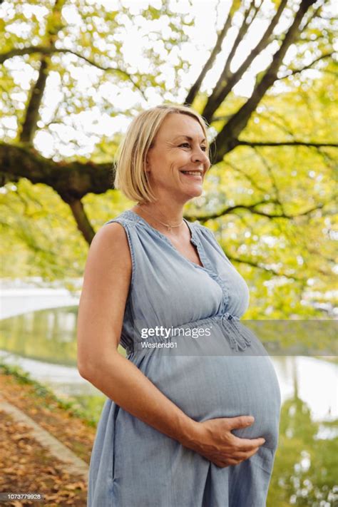 Happy Mature Pregnant Woman Standing In Park Photo Getty Images