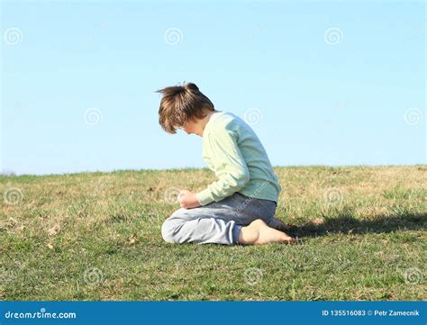 boy kneeling  meadow stock image image  meadow