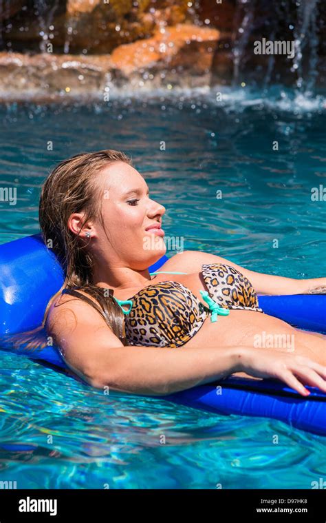 Young Woman In Bikini Relaxing On A Float In Domestic Swimming Pool