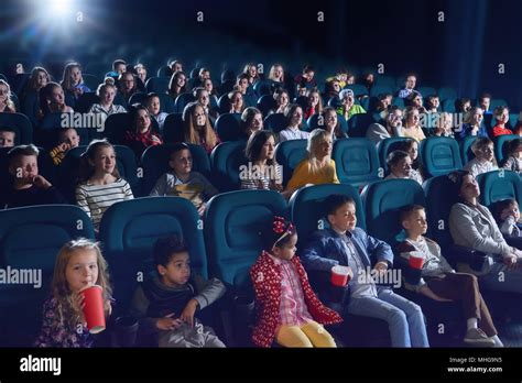 crowd  people sitting  comfortable seats  modern  theatre children teens adults