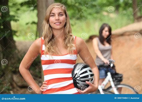 Two Girls Riding A Bike Making Funny Faces On Bluish Background