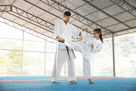 Girl Practicing Karate With Coach On Tatami Outdoors Stock Image