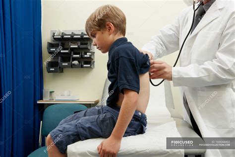 doctor examining young boy examination room medical examination stock photo