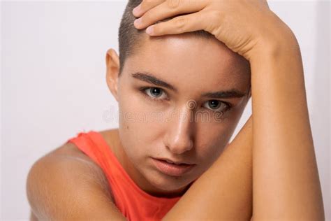 Caucasian Girl With Short Hair Almost Bald Holds Her Hands Behind Her