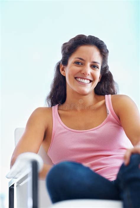 Woman Giving An Attractive Smile Portrait Of Woman Sitting On A Chair