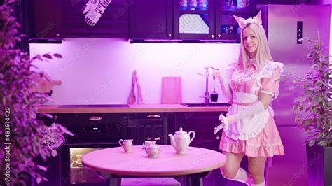 cute blonde maid in pink uniform show take a seat gesture to viewer
