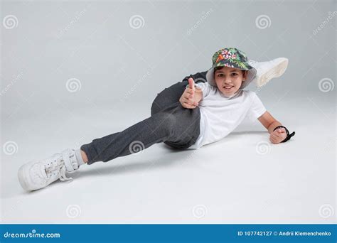active  boy lies   floor lifting  leg   head   gray background