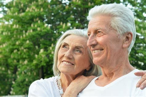 Close Up Portrait Of Beautiful Senior Couple Hugging In The Park Stock