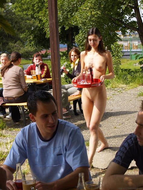 nude barmaid serving some outside tables nudeshots