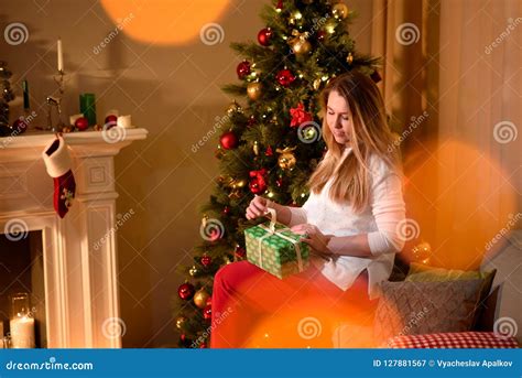 girl unwrapping christmas present holiday tree stock image image of