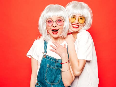 twee jonge sexy lachende hipster meisjes in witte pruiken
