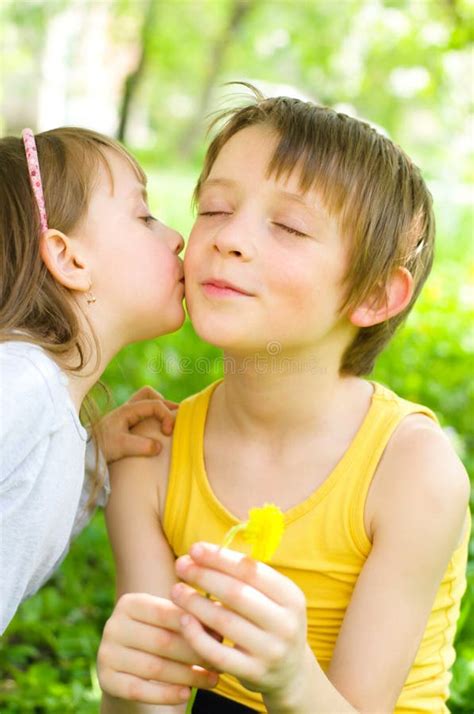 het jonge meisje geeft haar broer een kus op de wang stock foto image  leuk park