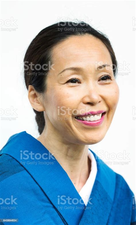 Mature Japanese Woman In Blue Kimono Smiling And Looking Away Stock