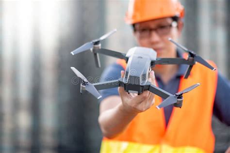 young asian engineer holding drone  construction site stock photo image  drone helmet