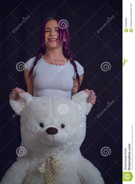 girl in an abandoned building with a teddy bear in his hands stock