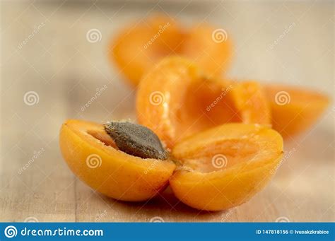 Fresh Ripened Apricots Cut In Halves With Stone On Wooden Table In