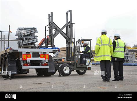 truck mounted fork lift truck unloads scaffolding equipment   flat bed articulated lorry