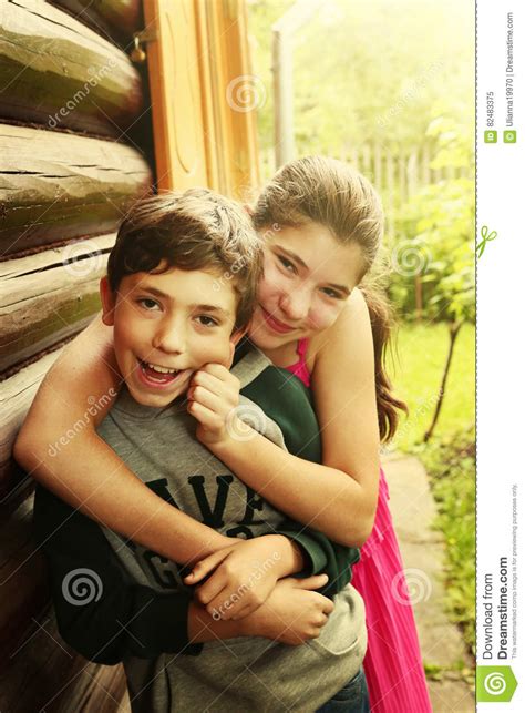 jardín adolescente de la sonrisa del abrazo de la muchacha del muchacho de los hermanos imagen