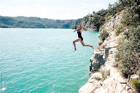 teen girl jumping  cliff   lake  provence  stocksy