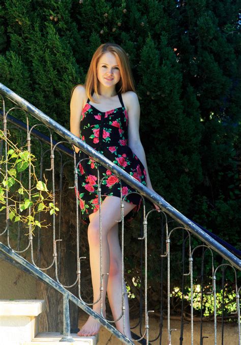 teen redhead starts taking dress off on the stairs and poses nude on the balcony