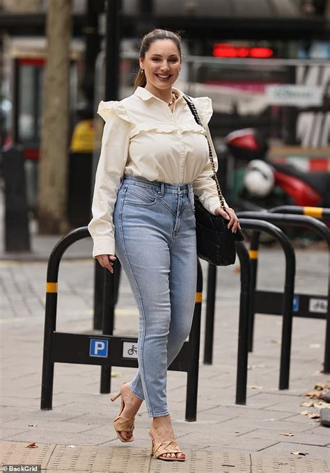 kelly brook cuts a chic figure in a yellow ruffled blouse and jeans as