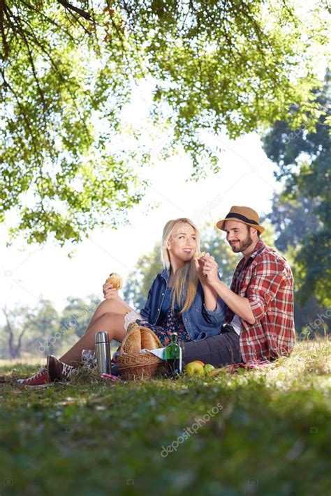 Beautiful Young Couple Having Picnic In Countryside Happy