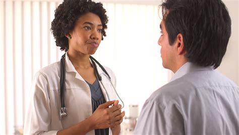 female doctor holding hispanic woman s hand and talking stock footage video 6646082 shutterstock