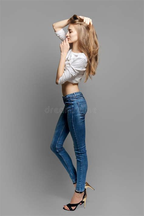 Atractiva Modelo De Moda Con Largas Piernas Delgadas En Jeans Posando Y
