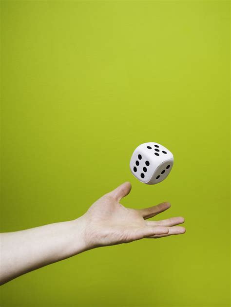 photo man throwing  large white dice