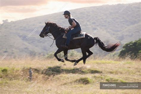 man riding horse  rural landscape focus concept young man stock