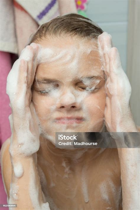 a teenage girl soaped with a soapy foam face bathing in the bathroom