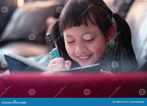 happy  child girl lying  sofa  learning  laptop  writing  book  homesocial