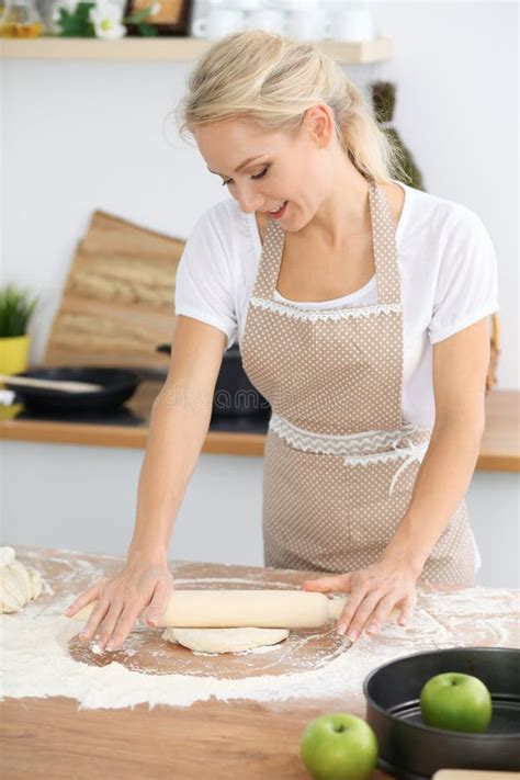 Blonde Woman Rolling The Dough For Cooking Holiday Pie Or Cookies In