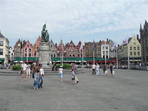 people  walking    open area  buildings   statue    side