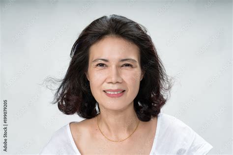 portrait of beautiful mature asian woman with curly hair style smiling